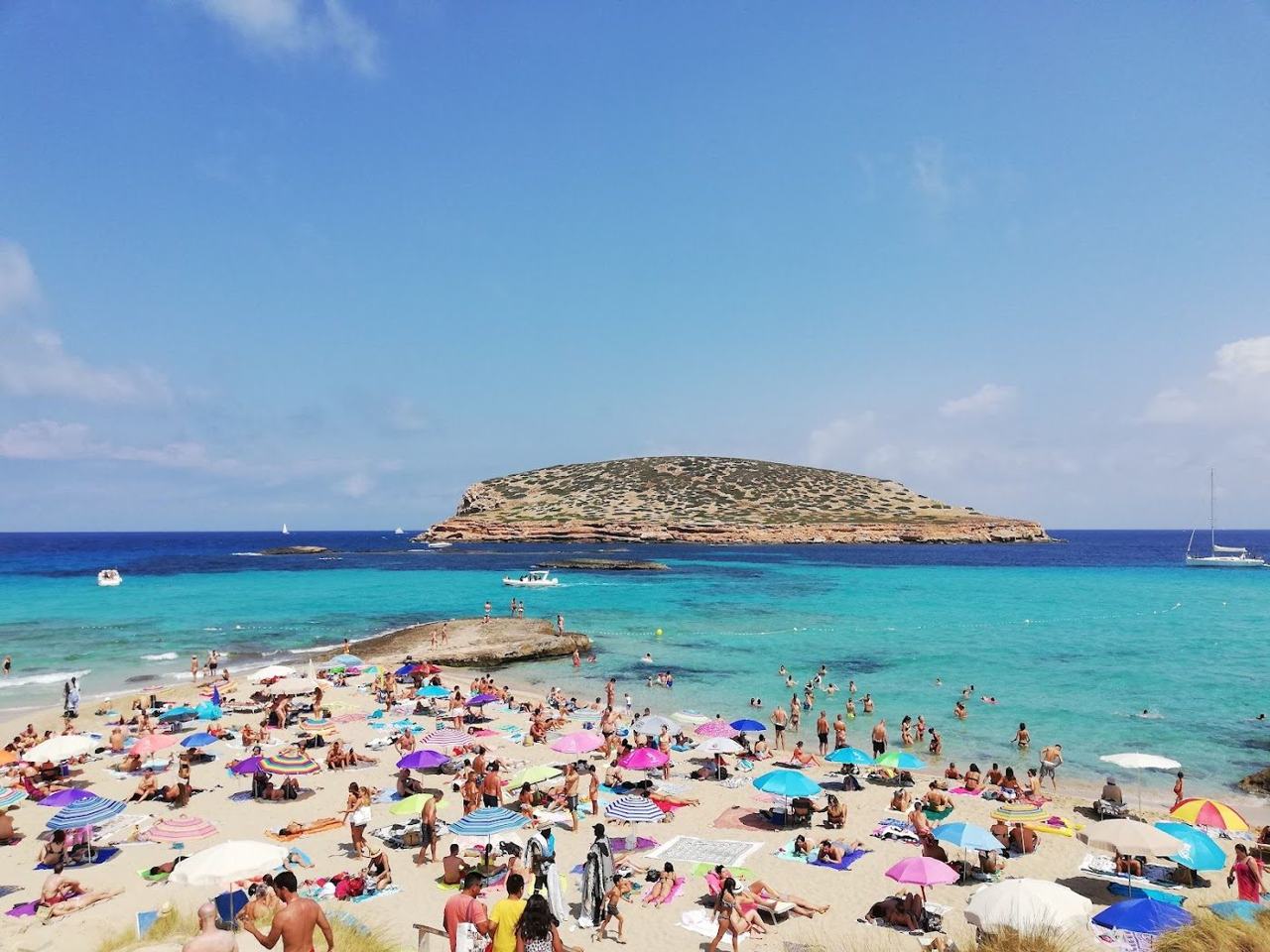 The clear shallow water and rocky islets off Cala Comte on Ibiza at golden hour
