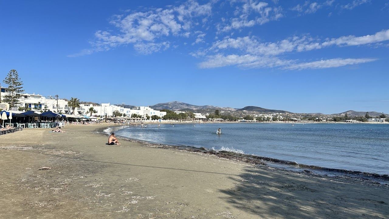 The shallow calm water and sandy shore of Agios Georgios beach on the southern edge of Naxos Town