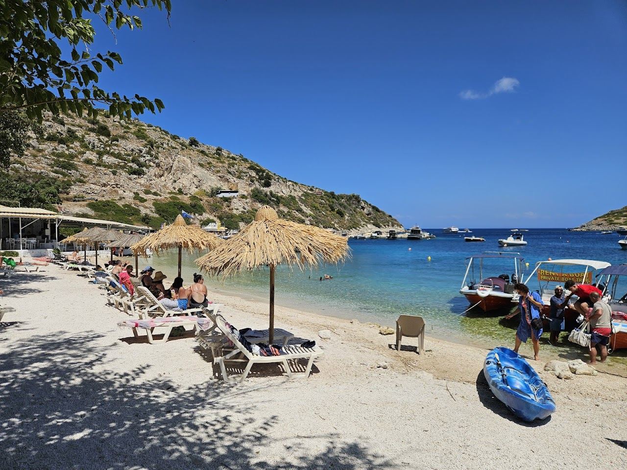 The small organised beach and harbour of Agios Nikolaos on the north of Zakynthos with clear water