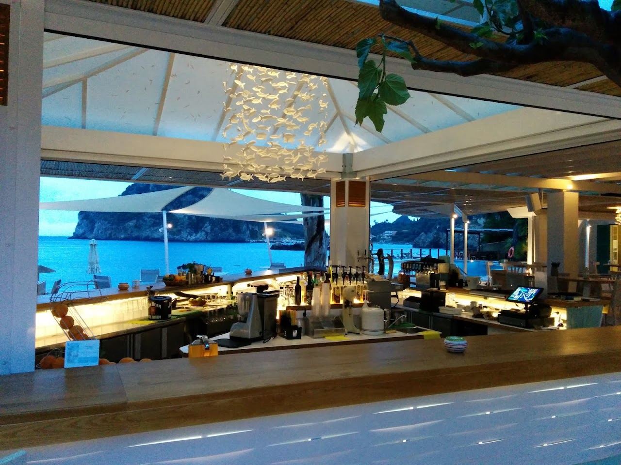 The terrace and loungers of Akron above the Agia Triada inlet at Paleokastritsa in Corfu
