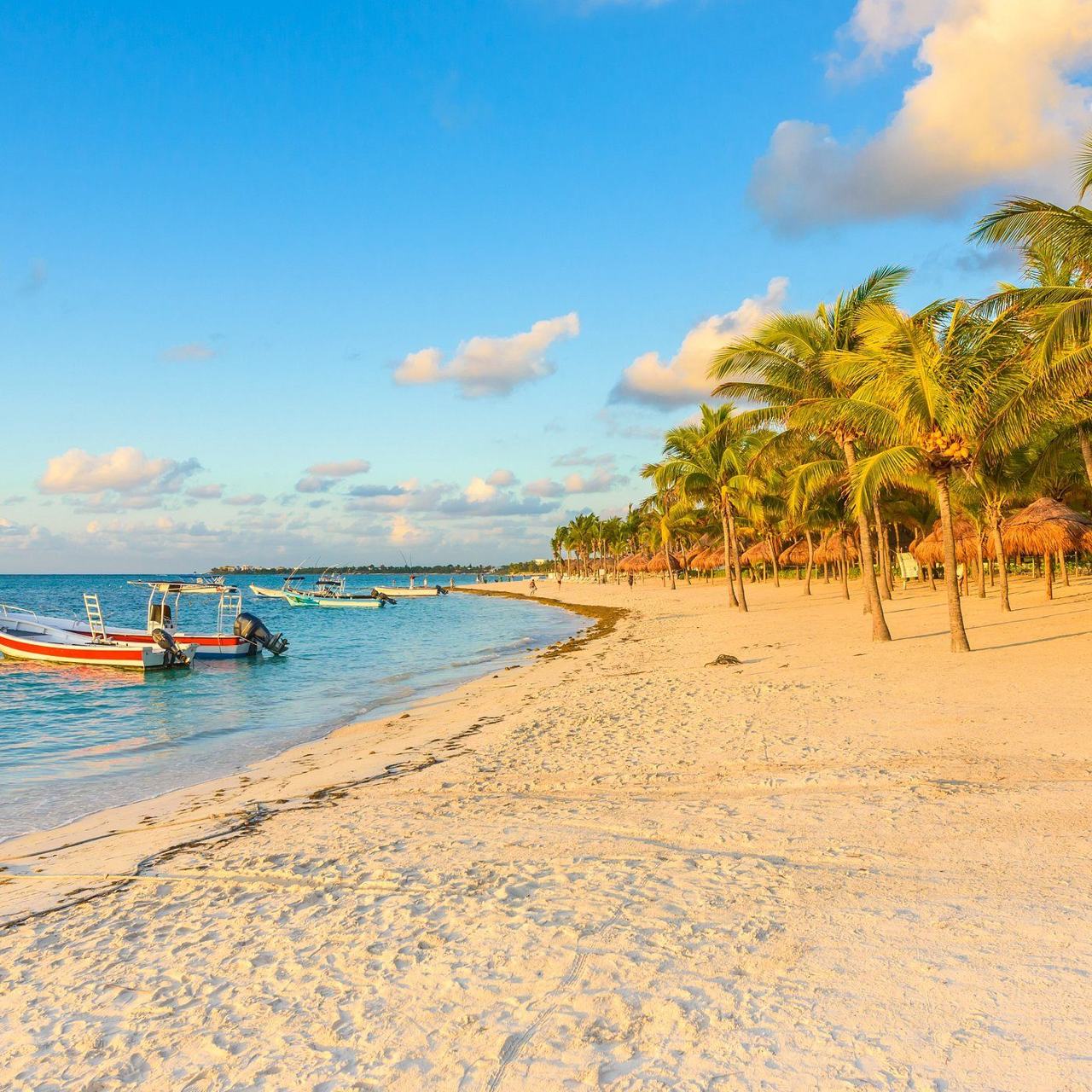 Calm shallow turquoise water and pale sand along the crescent bay at Akumal in the Riviera Maya