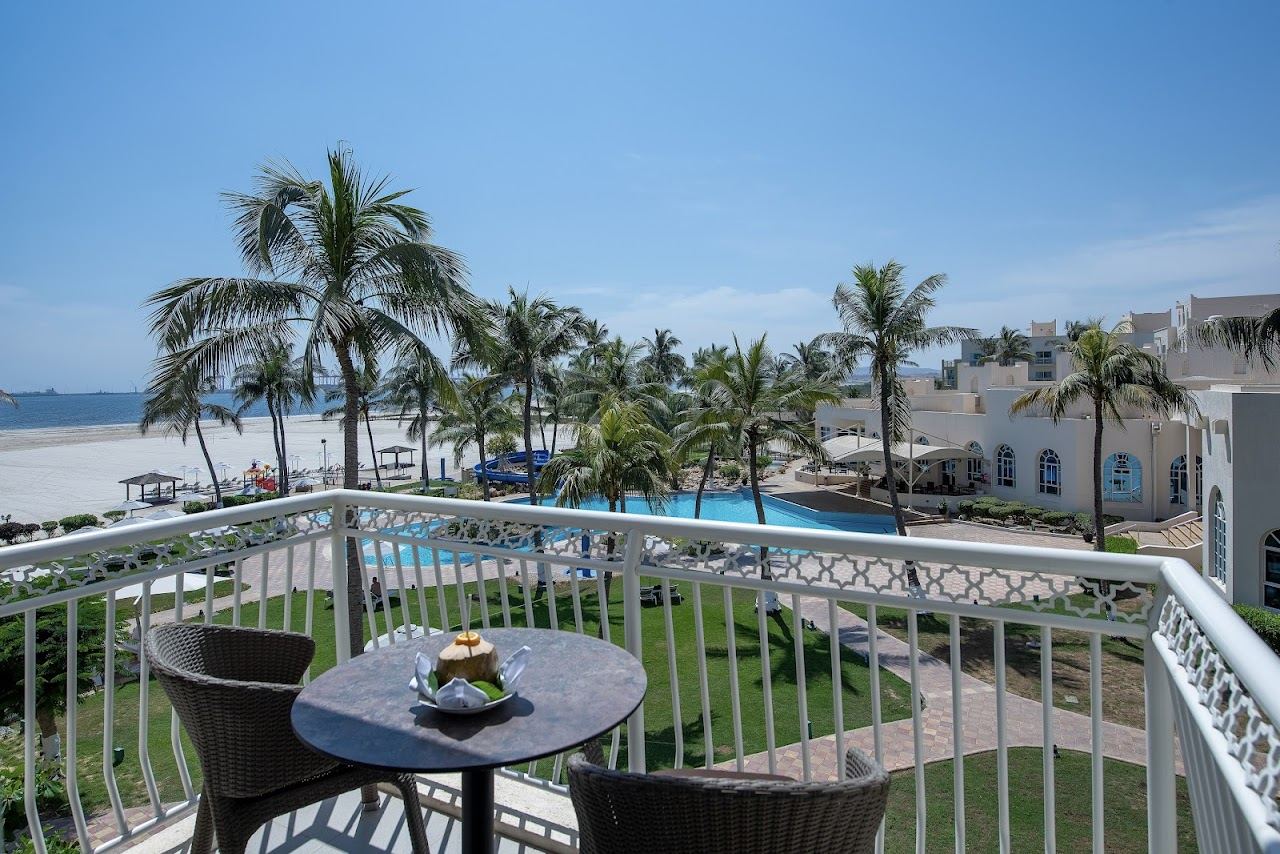 A palm fringed resort beach and pool along the city coast near Al Haffa in Salalah
