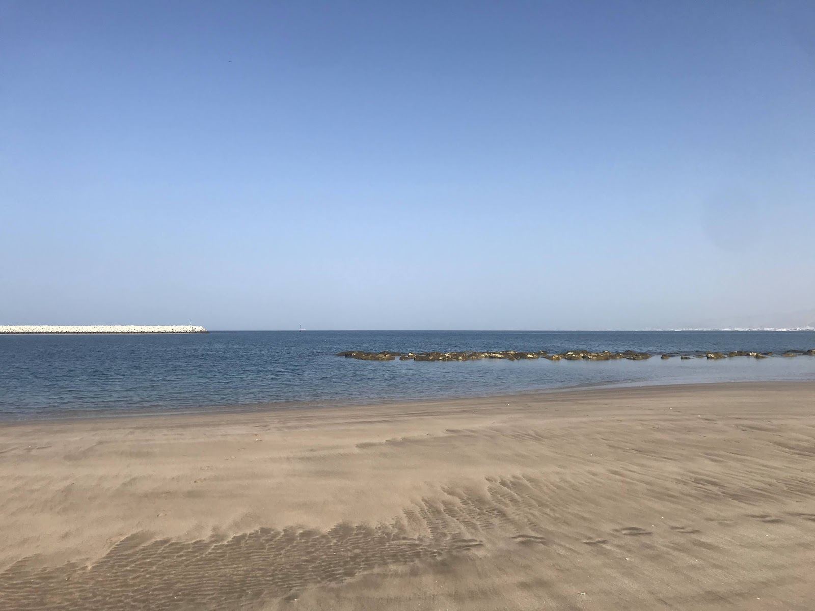 Calm pale sand and marina promenade at Al Mouj Beach in Muscat, Oman