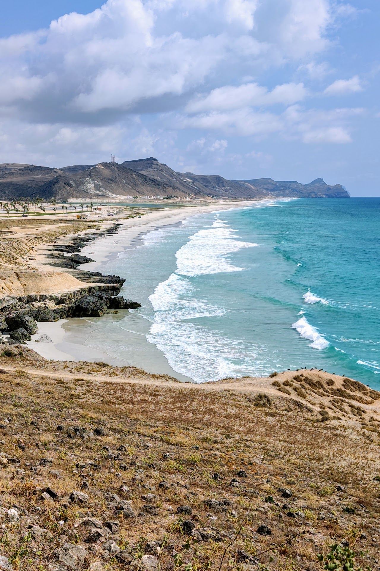 Spray rising from the blowholes and the boardwalk below the cliffs at Al Mughsail near Salalah