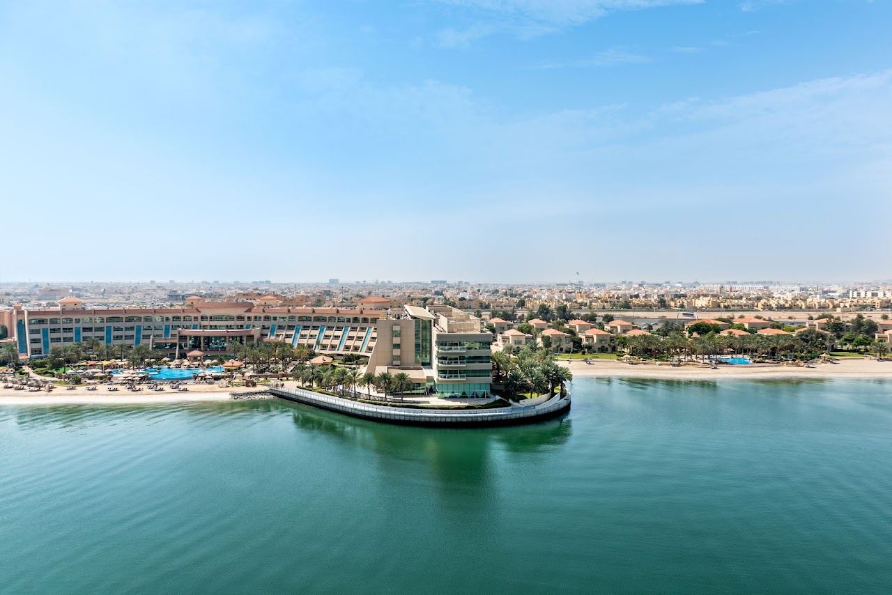Calm lagoon water and palm fringed sand at Al Raha Beach on the eastern Abu Dhabi waterfront