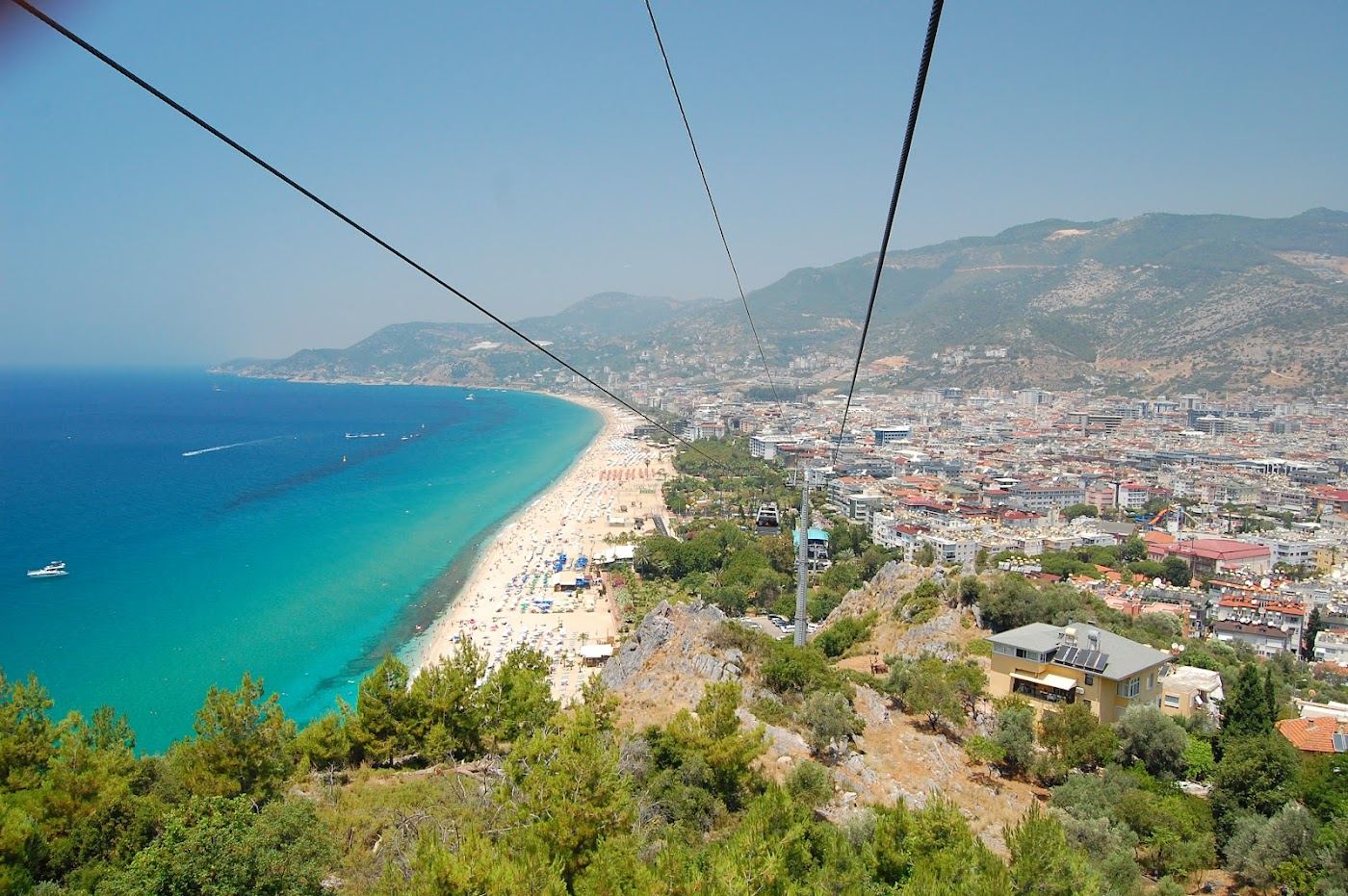 Pale fine sand and clear calm water at Cleopatra Beach below the Alanya castle headland