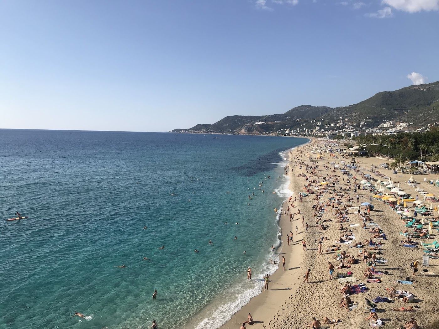 Fine pale sand and clear sea below the castle headland at a central Alanya beach