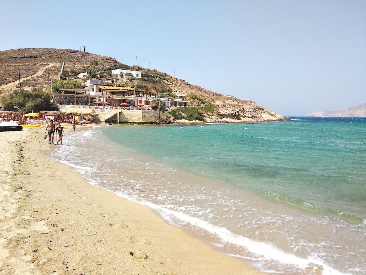 The wide open sweep of Ftelia beach on the north coast of Mykonos with bare hills behind