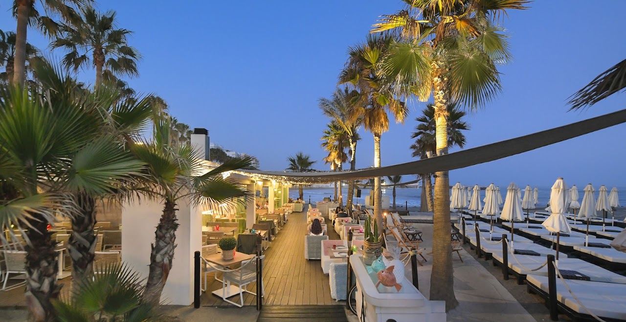 Sunbeds and sea view on the wooden deck at Amare Beach club in Marbella