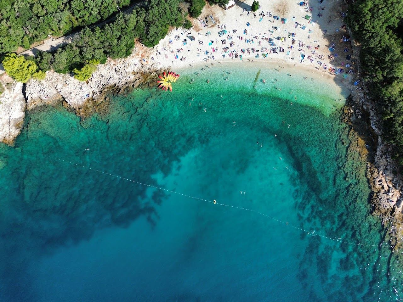 Pebble beach and clear blue Adriatic water at Ambrela on the Verudela peninsula near Pula in Istria