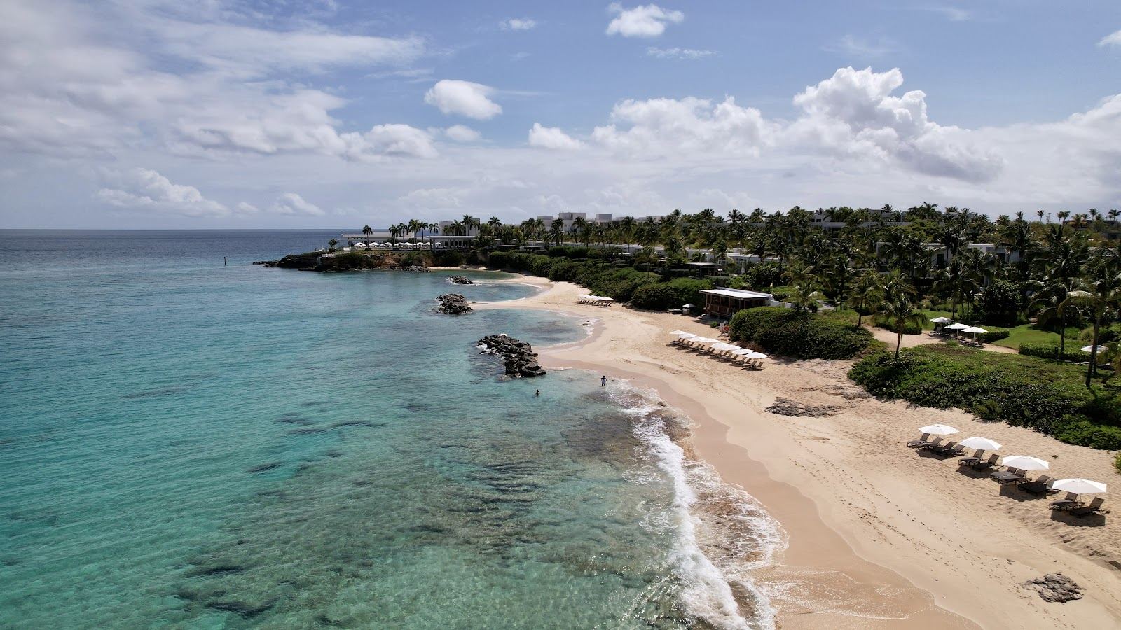 The calm palm lined west coast sand of Barnes Bay in Anguilla catching the evening light