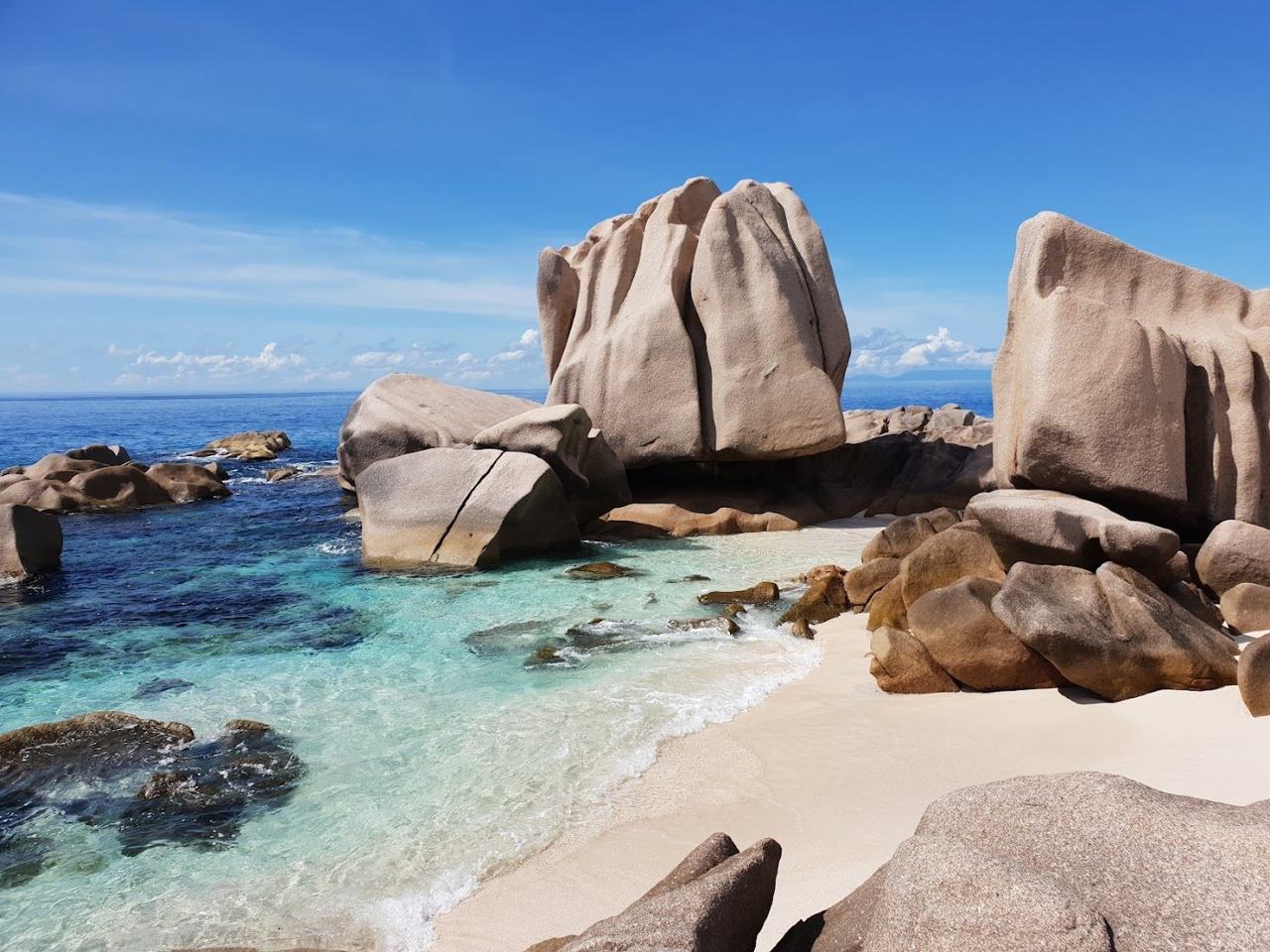 Granite boulders and clear water at the secluded Anse Marron on La Digue reached by guided hike