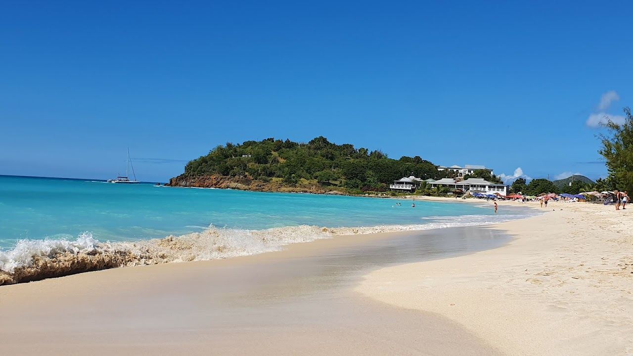 Golden sand, headland and calm Caribbean water in the soft evening light at Ffryes Bay in Antigua
