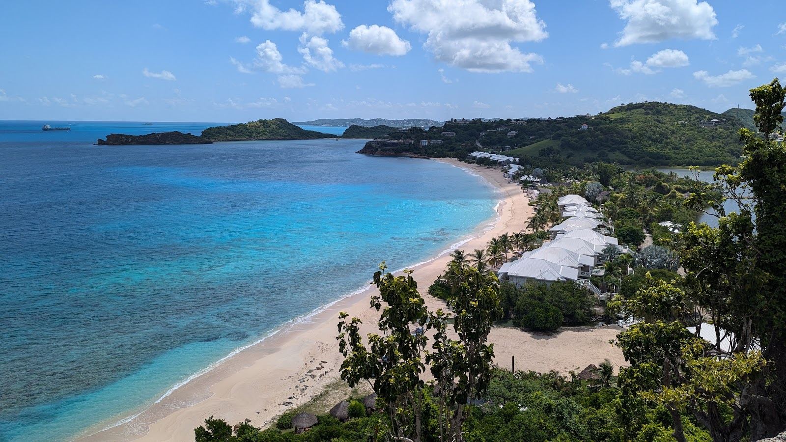 A calm curve of pale sand and clear turquoise water on the quiet west coast of Antigua