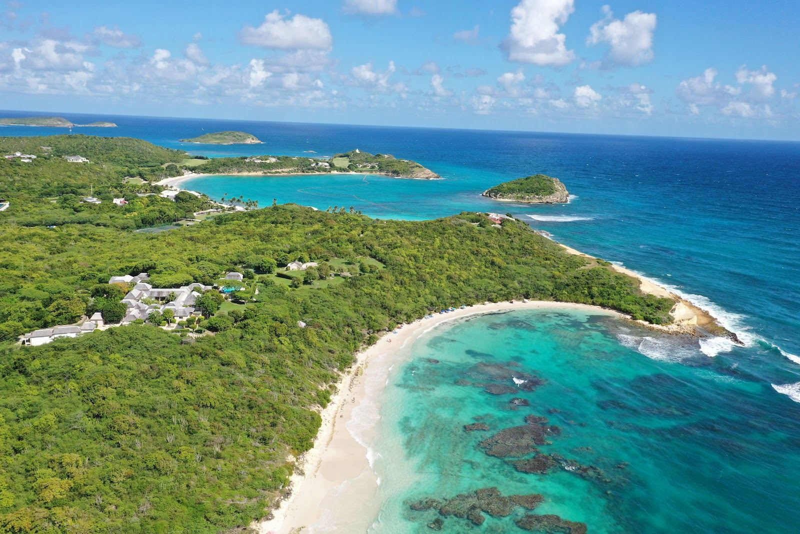An empty curve of pale sand and turquoise water at a quiet beach in Antigua.