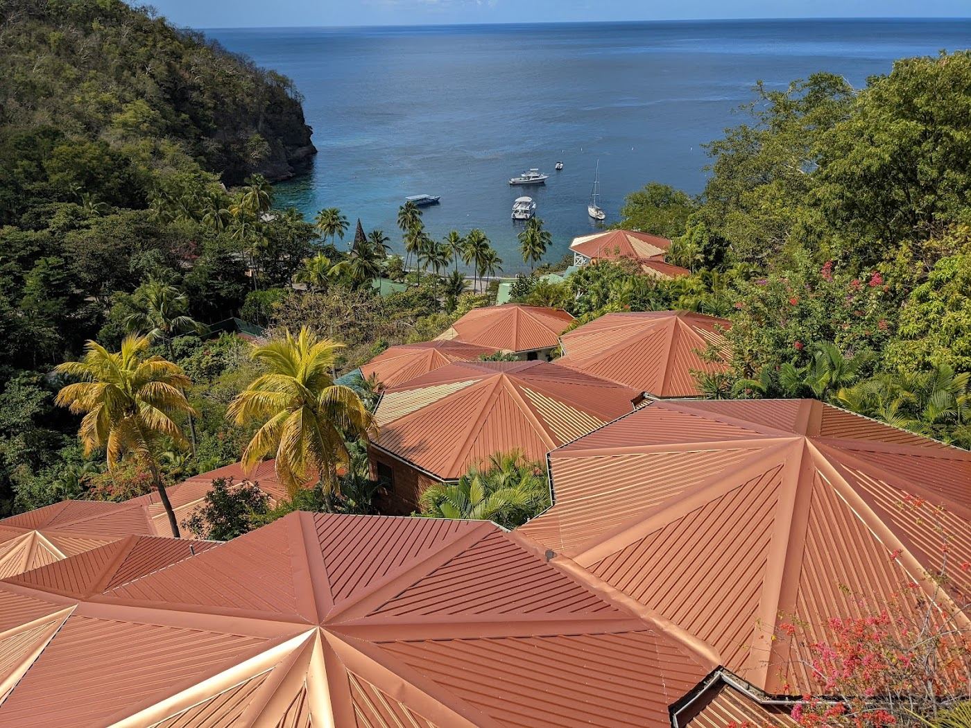 An adults only beach resort with loungers on white sand over a calm turquoise bay