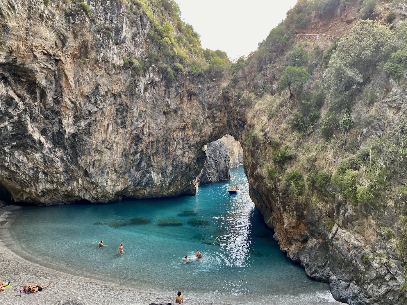 The natural rock arch and small sand and pebble beach at Arcomagno in northern Calabria