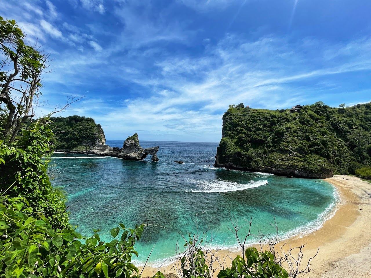 The white sand cove of Atuh Beach below tall cliffs and rock spires on Nusa Penida