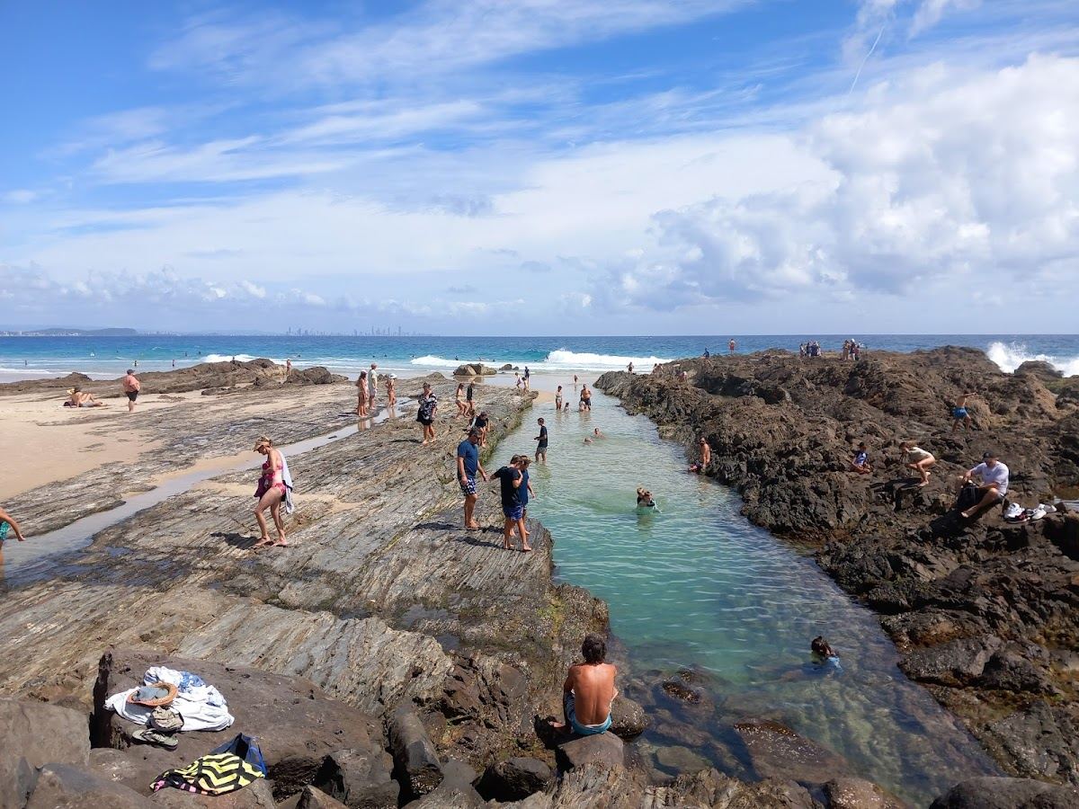 Surfers riding the Superbank point wave at Snapper Rocks on the Gold Coast