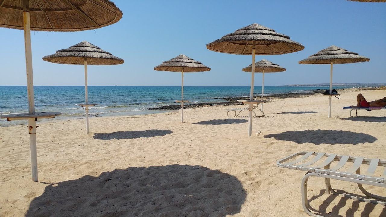 Soft golden sand and shallow clear water at Ayia Thekla beach near Ayia Napa in Cyprus