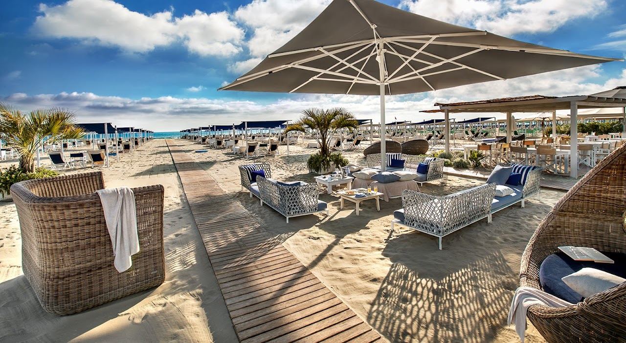 Rows of private beach tents and umbrellas on the sand at Bagno Dalmazia in Forte dei Marmi