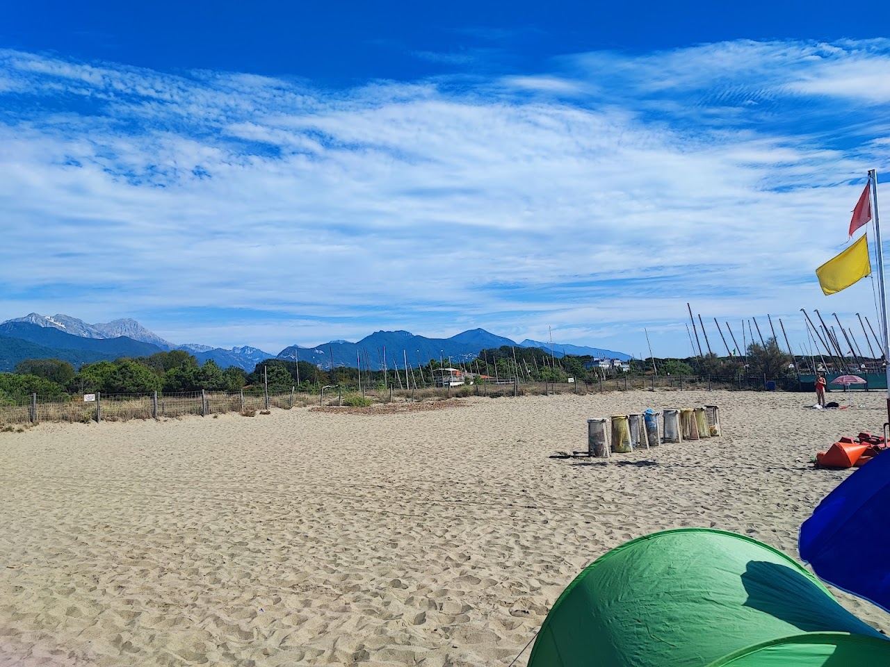 Fine pale sand and gentle shallows along the Forte dei Marmi shore with the Apuan Alps behind