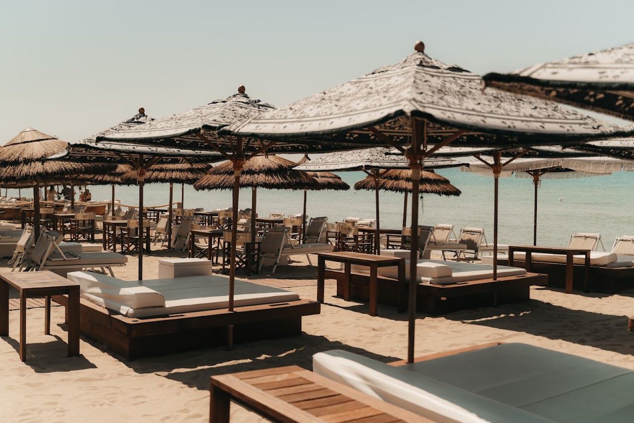 Loungers and umbrellas on pale sand in front of Bahia Porto Cesareo on the Torre Lapillo shore