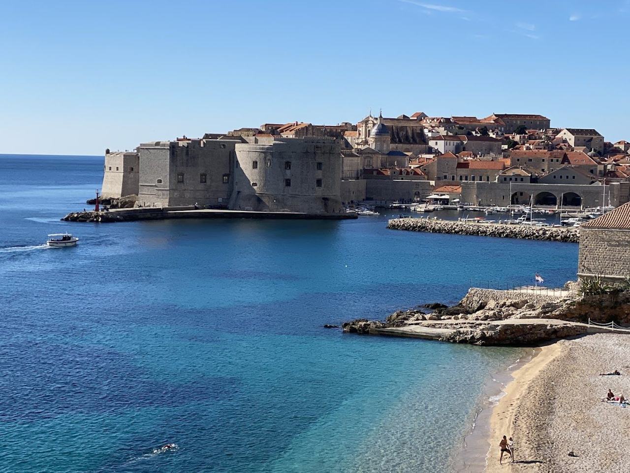 Banje Beach pebble shore just outside the Old Town walls of Dubrovnik with Lokrum island beyond