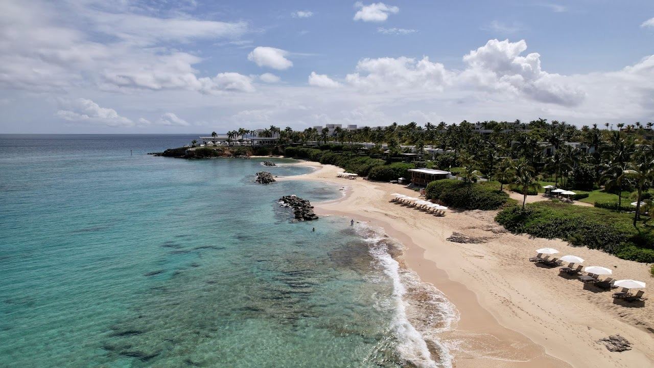 Palm lined soft sand and calm clear water at Barnes Bay on the west coast of Anguilla