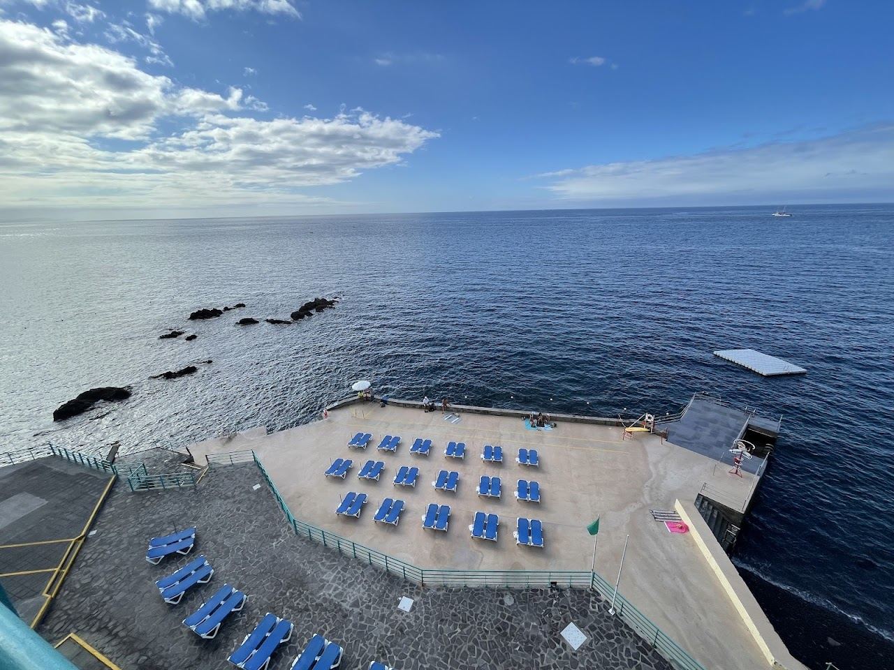 Sun decks and the dark pebble shore at the Barreirinha bathing complex in Funchal's Old Town