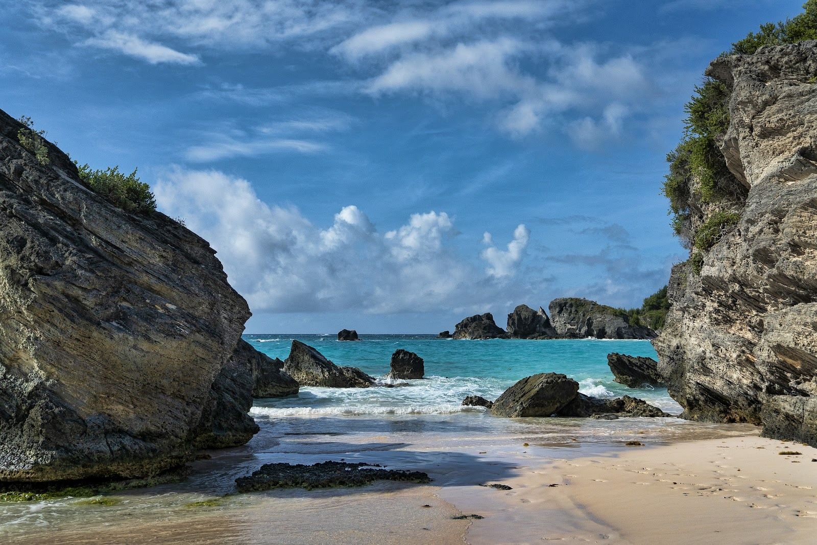 Calm turquoise water and pale pink sand in a sheltered cove on the south shore of Bermuda