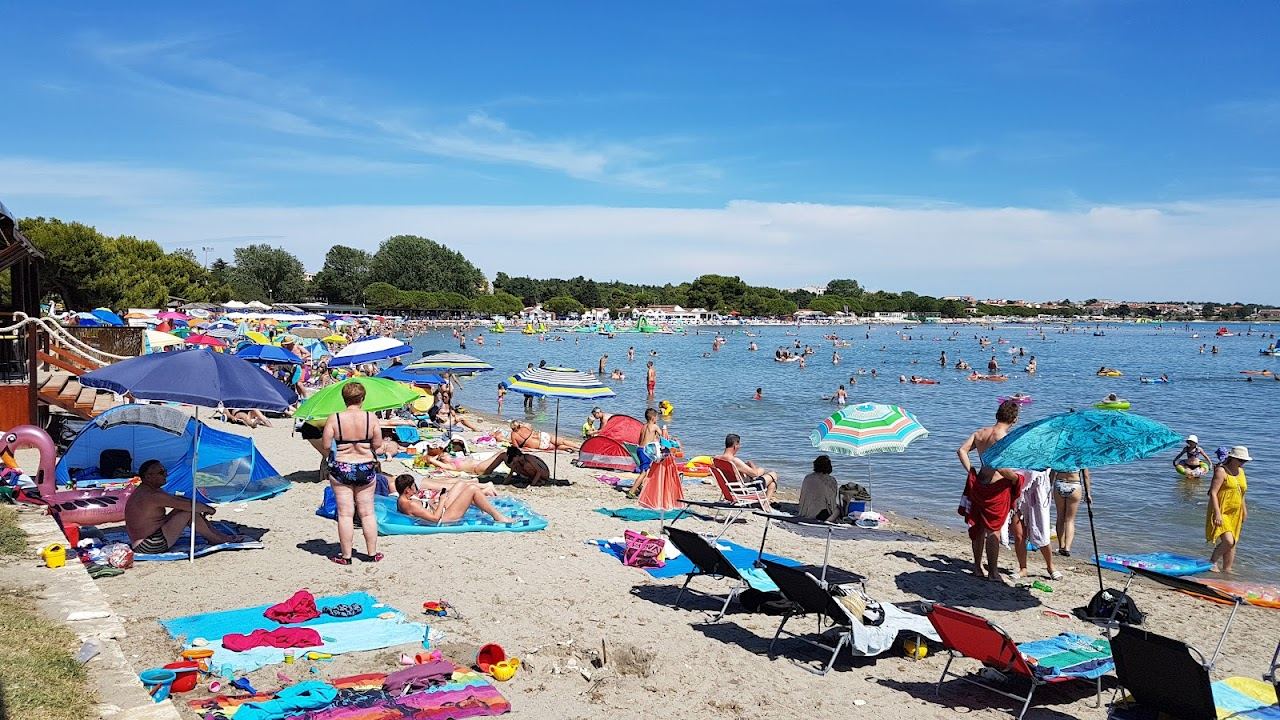Soft sand and shallow calm water at Bijeca beach in Medulin in southern Istria