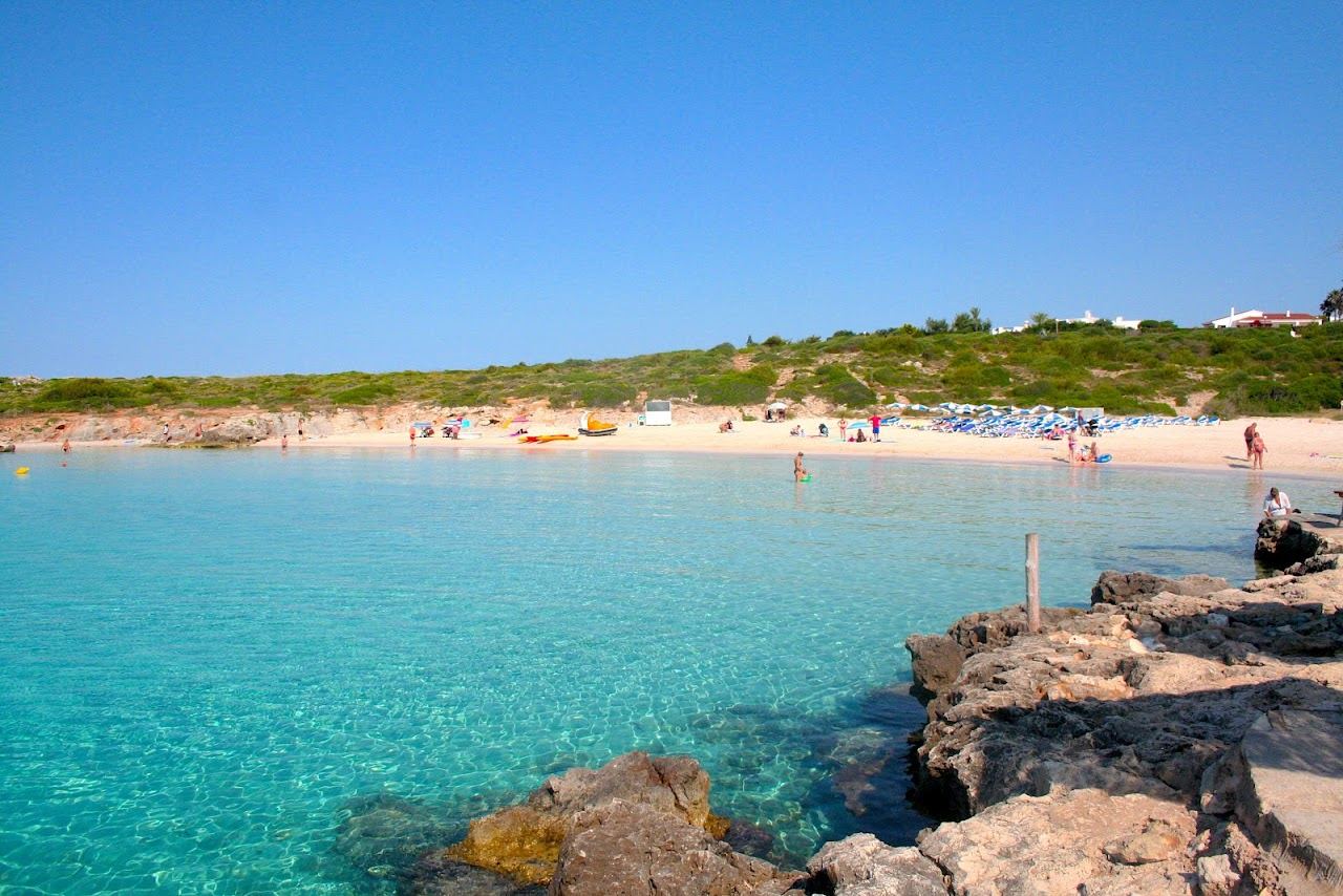Calm golden sand cove at Binibeca beach in Menorca