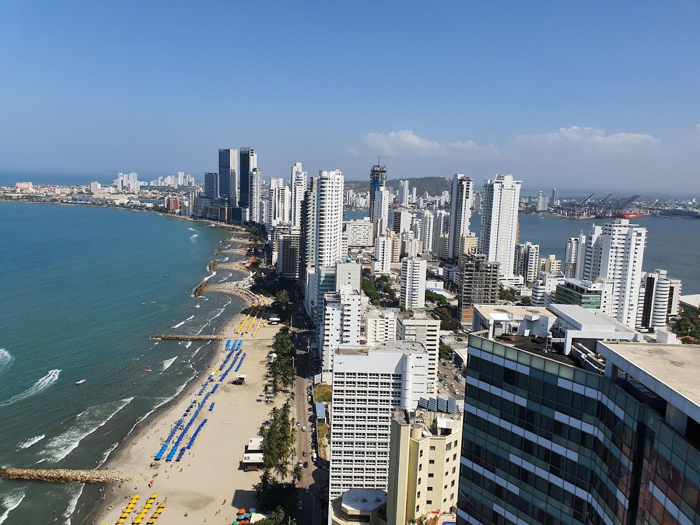 The grey sand and high rise skyline of Bocagrande beach in Cartagena at golden hour