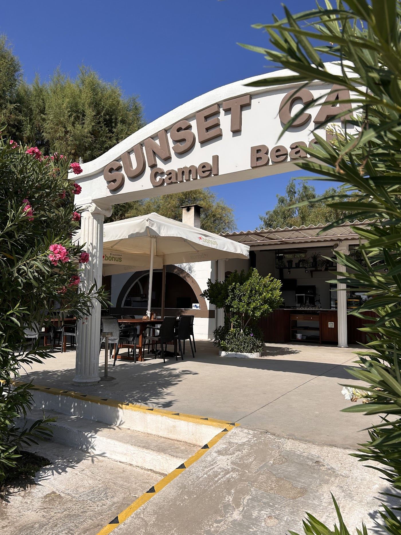 Sandy bay between two headlands with loungers at Camel Beach in Ortakent near Bodrum