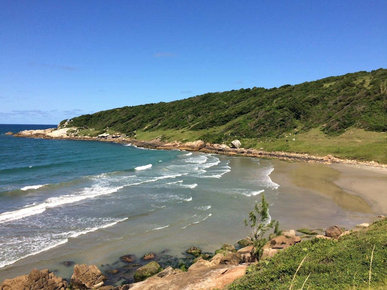 The green hills and surf bay of Praia do Rosa in Santa Catarina