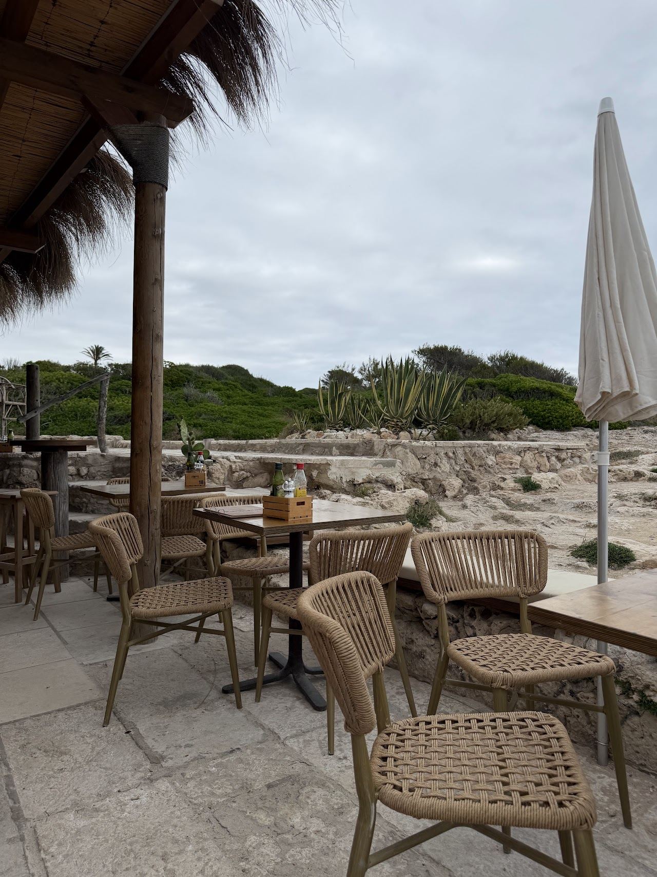 Seafront tables on the rocks at Los Bucaneros chiringuito at the edge of Binibeca cove in Menorca