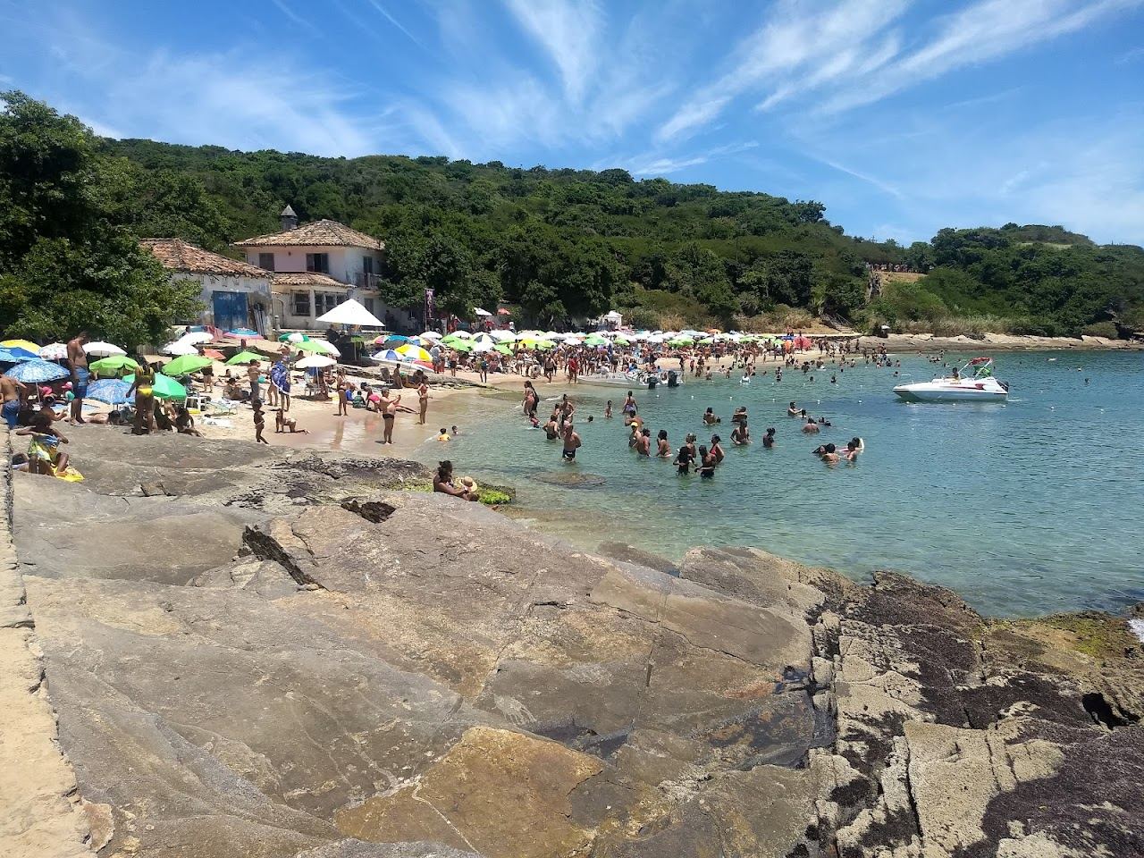 Sheltered clear water and soft sand with green headland at Praia Azeda in Buzios