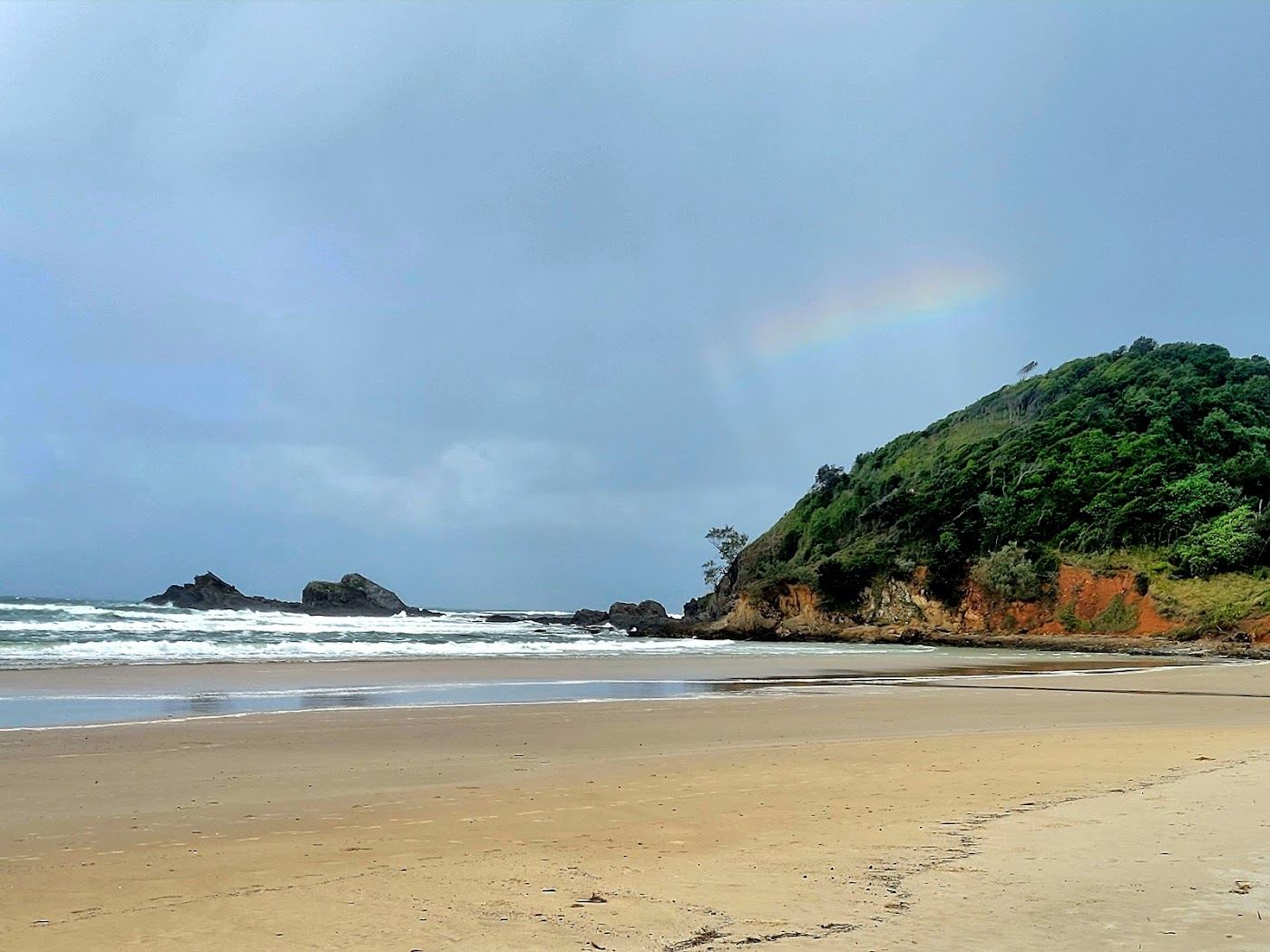 The quiet forested cove and empty sand of Broken Head beach south of Byron Bay