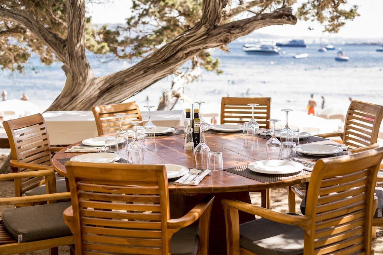 The white sand and turquoise water of Cala Bassa cove backed by pines on the west coast of Ibiza