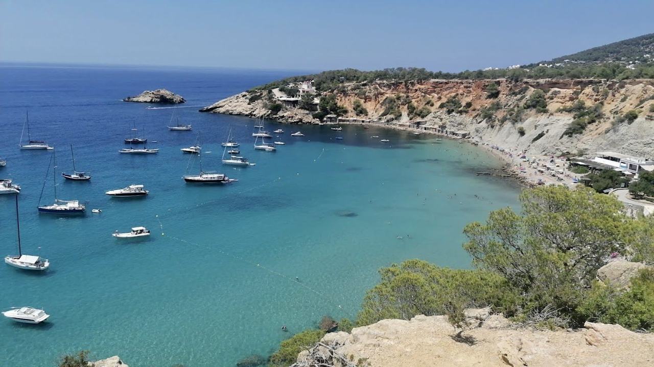 The beach of Cala d'Hort with the islet of Es Vedra rising from the sea on the southwest coast of Ibiza