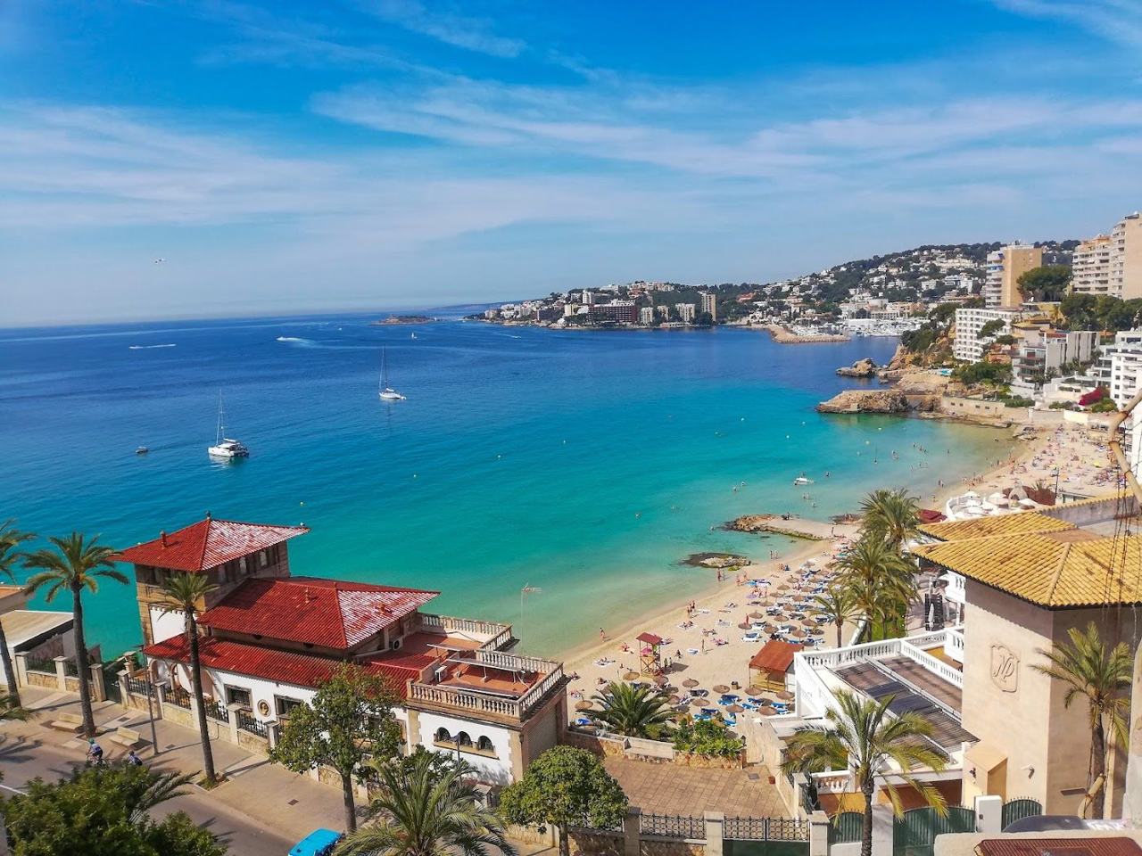 The compact golden sand and calm sheltered water of Cala Major just west of Palma in Mallorca