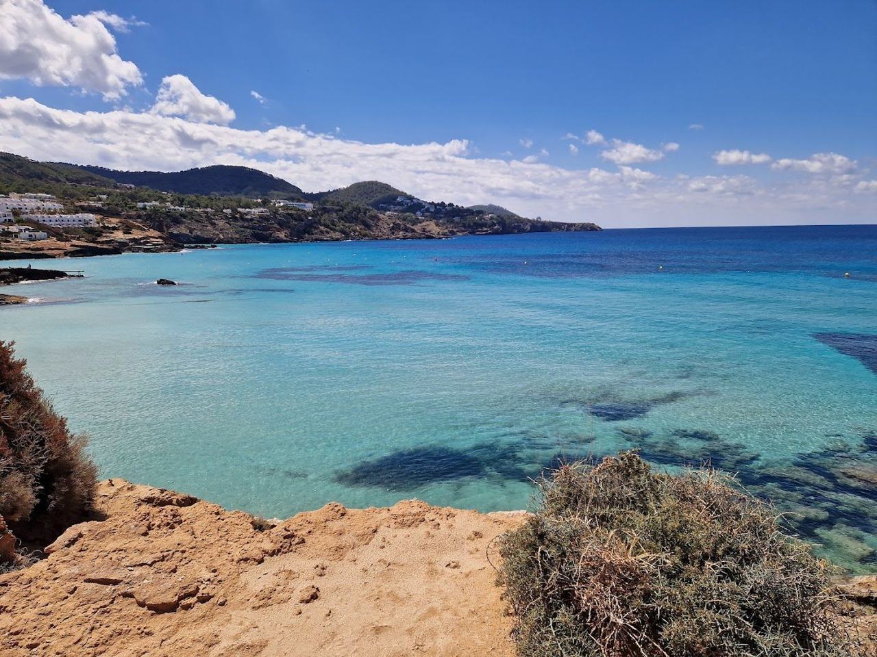 The wide golden sand and shallow clear water of Cala Tarida on the southwest coast of Ibiza