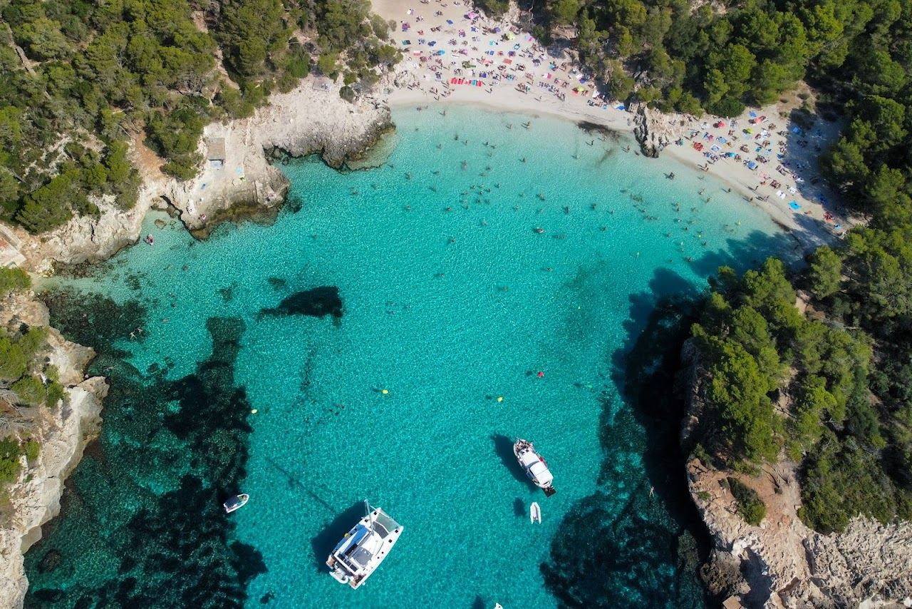 Sheltered white sand and turquoise water at Cala Turqueta in Menorca