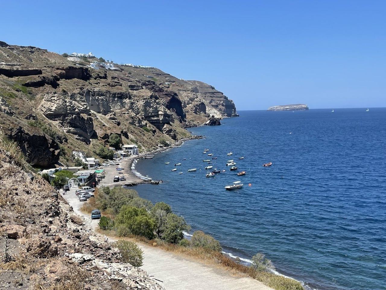 Clear water and dark gravel at the secluded Caldera Beach below Akrotiri
