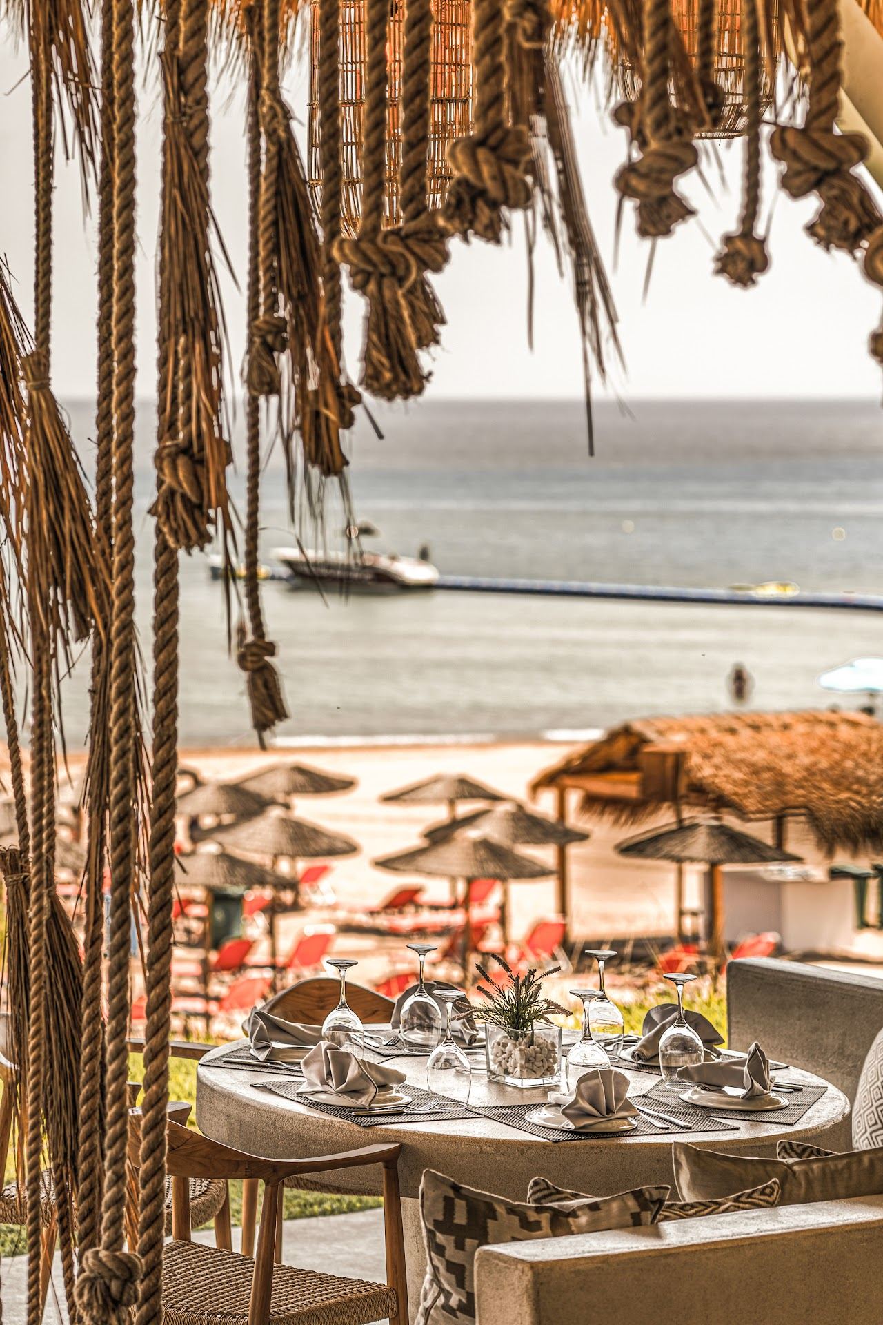 Umbrellas and wooden cabanas of Casa Playa on the golden sand of Banana Beach in Zakynthos