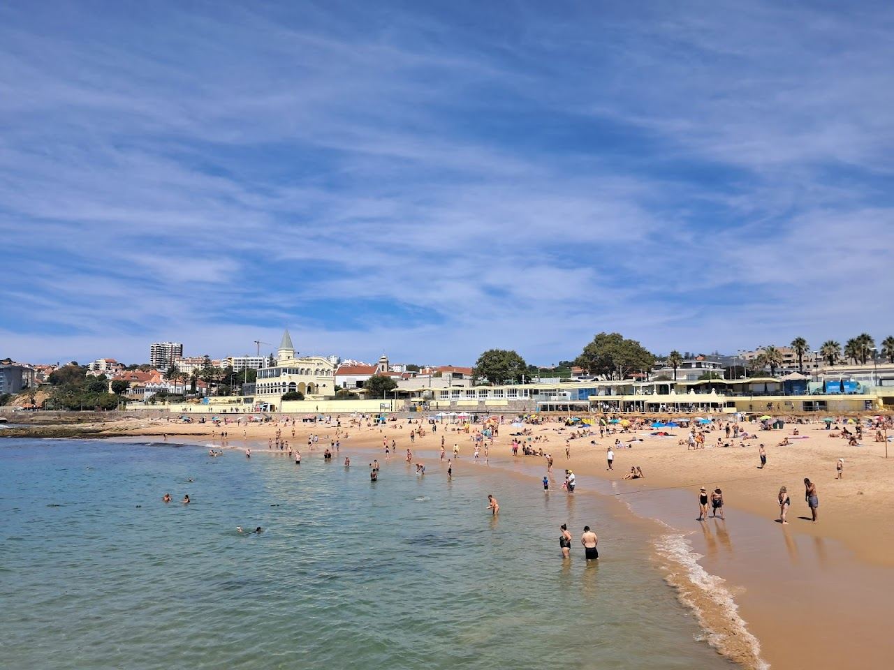 Sheltered golden town beach below the seafront promenade at Praia do Tamariz in Estoril