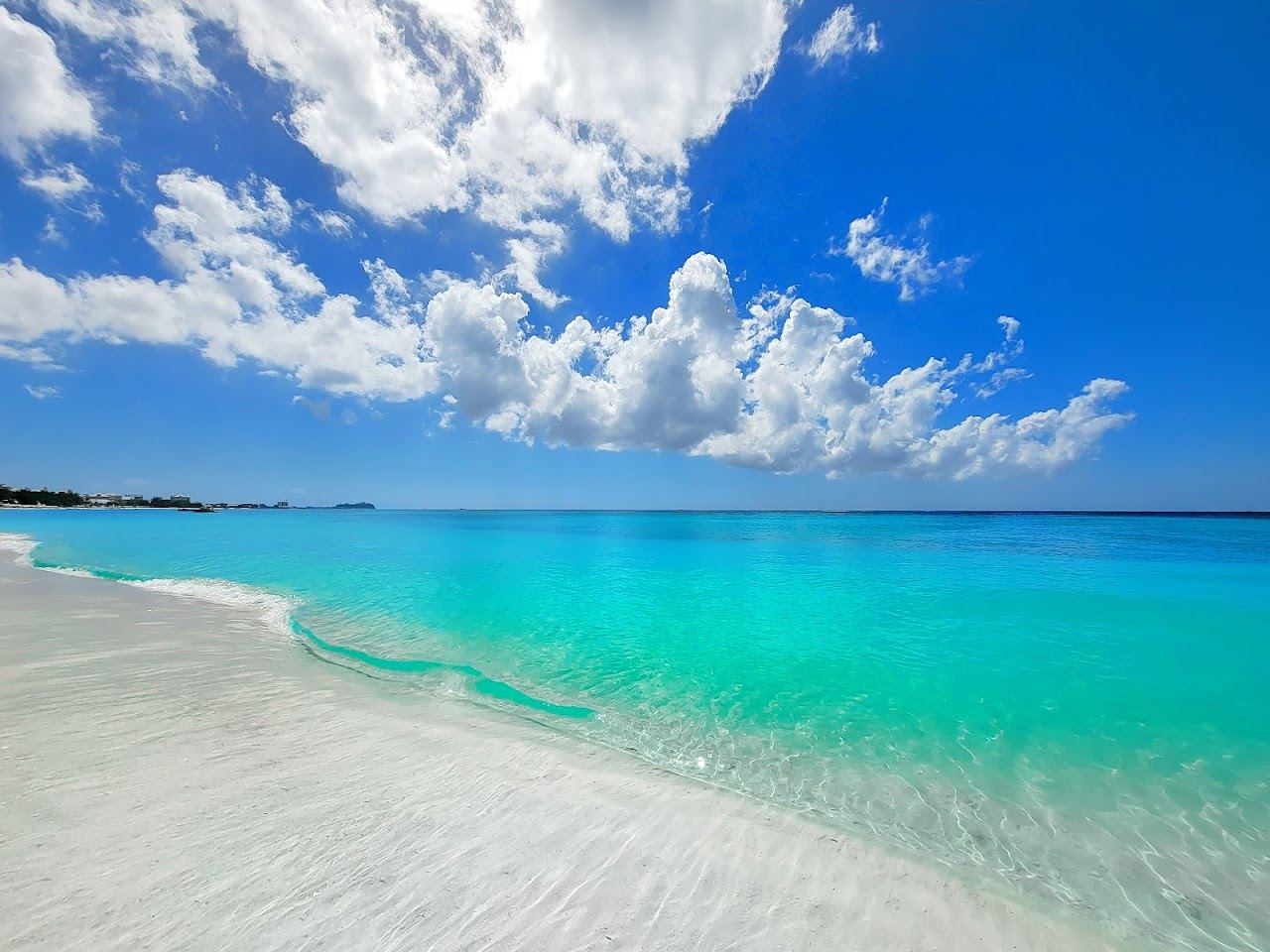 Calm turquoise water and powdery white sand along Seven Mile Beach on Grand Cayman