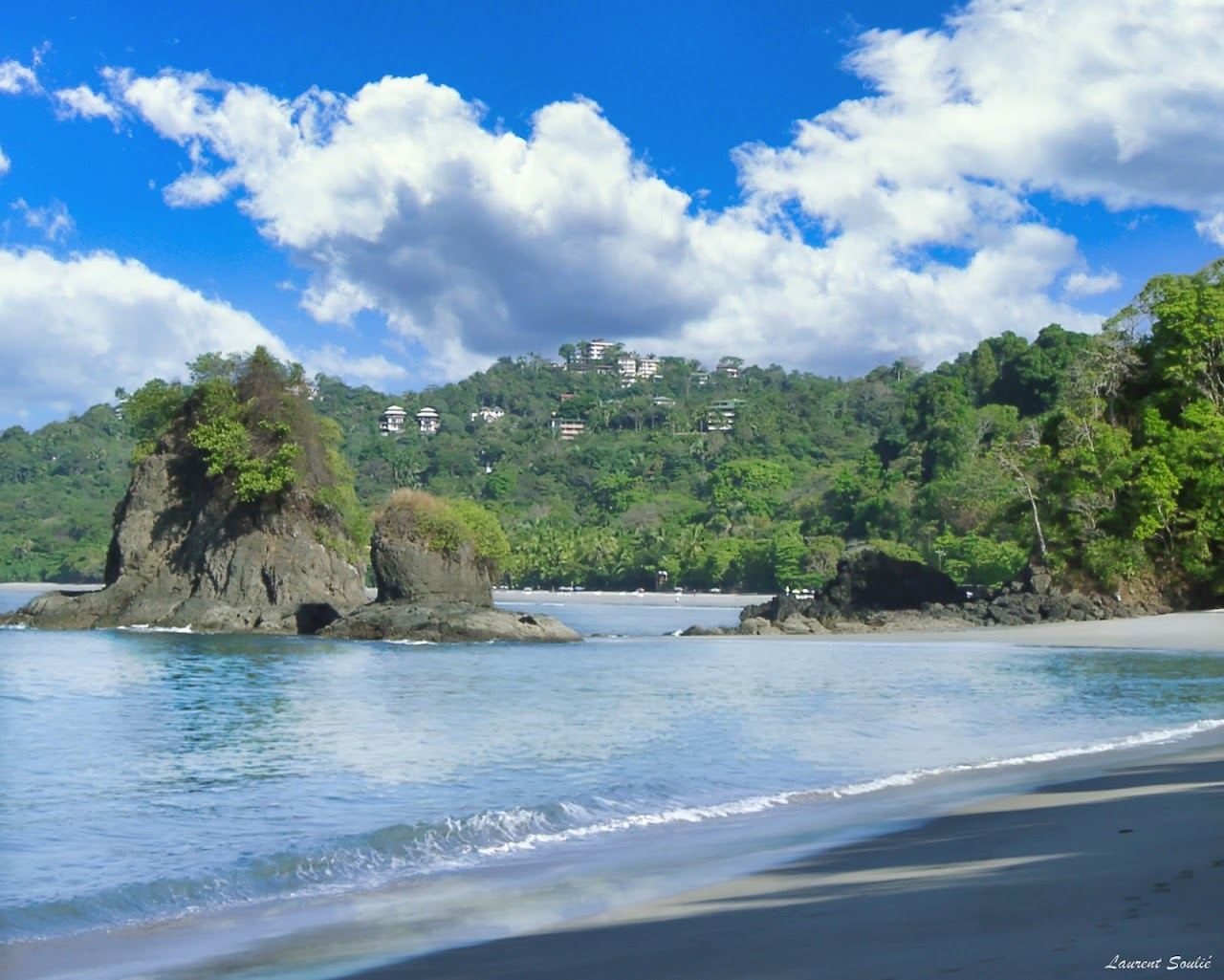 Jungle meeting a curve of pale sand and blue water at Manuel Antonio on the Pacific coast of Costa Rica