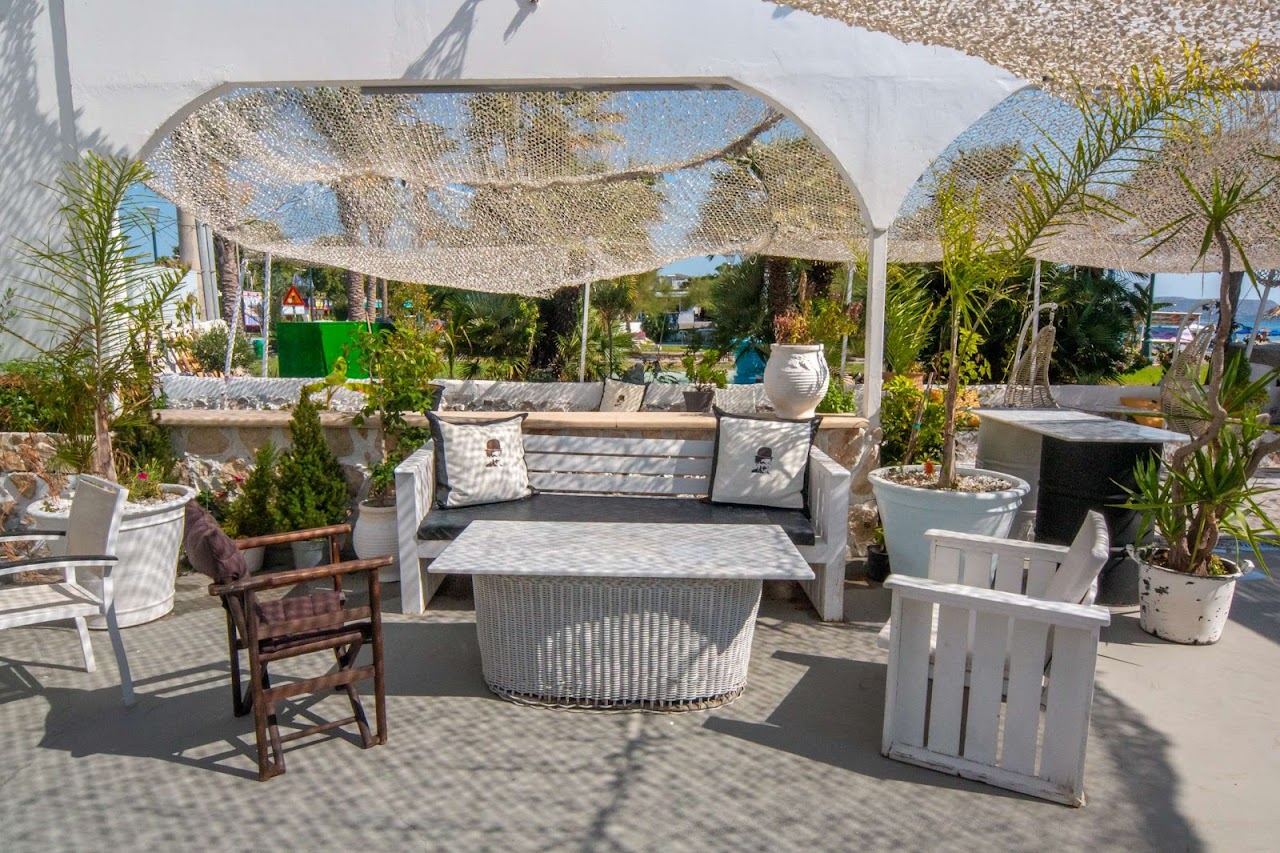 Tables and parasols of Chaplin's Beach Bar on the sand in the centre of Faliraki beach on Rhodes